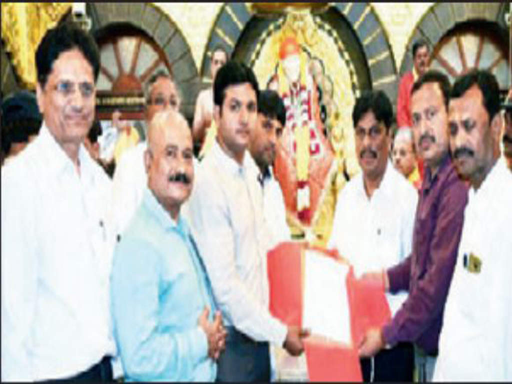 Vasai farmer Kashinath Patil (second from right) hands over papers of two buildings for the charitable institute in Shirdi