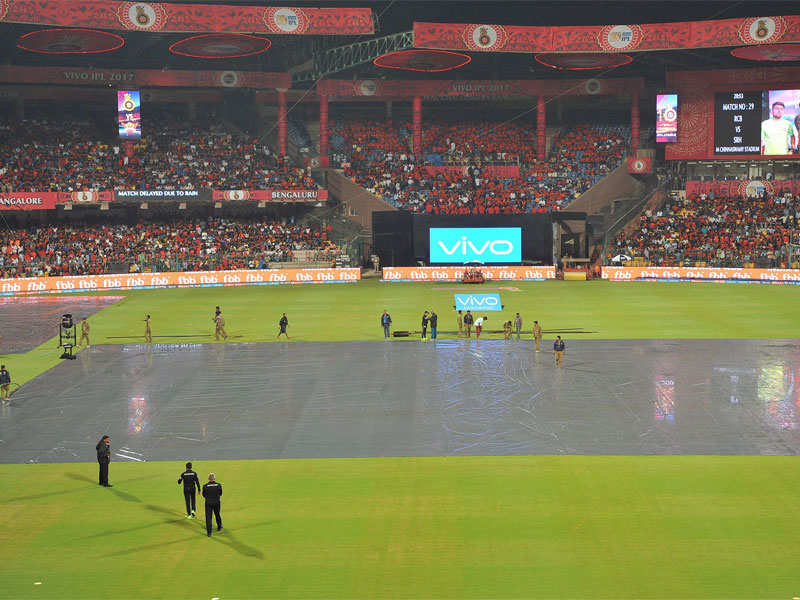 Officials and groundsmen are seen on the pitch after rain delayed the start of an IPL match. (AFP Photo)