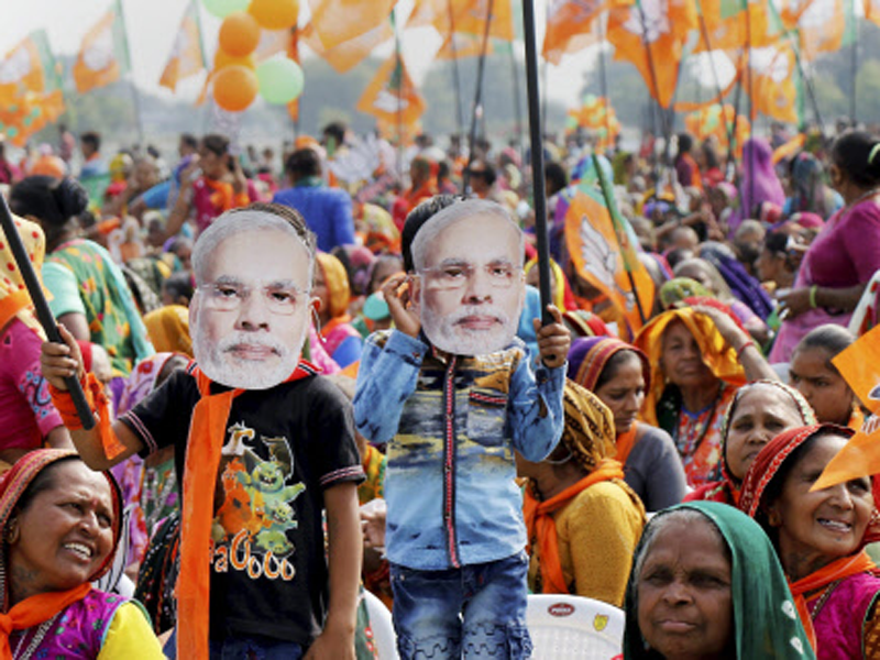 Supporters wear mask of PM Modi during an election campaign rally in support of BJP candidates, in Sanand. (PTI File Photo)
