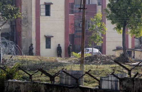 Army soldiers take positions outside the residential quarters located inside the Sunjwan Army camp in Jammu, after a terrorist attack