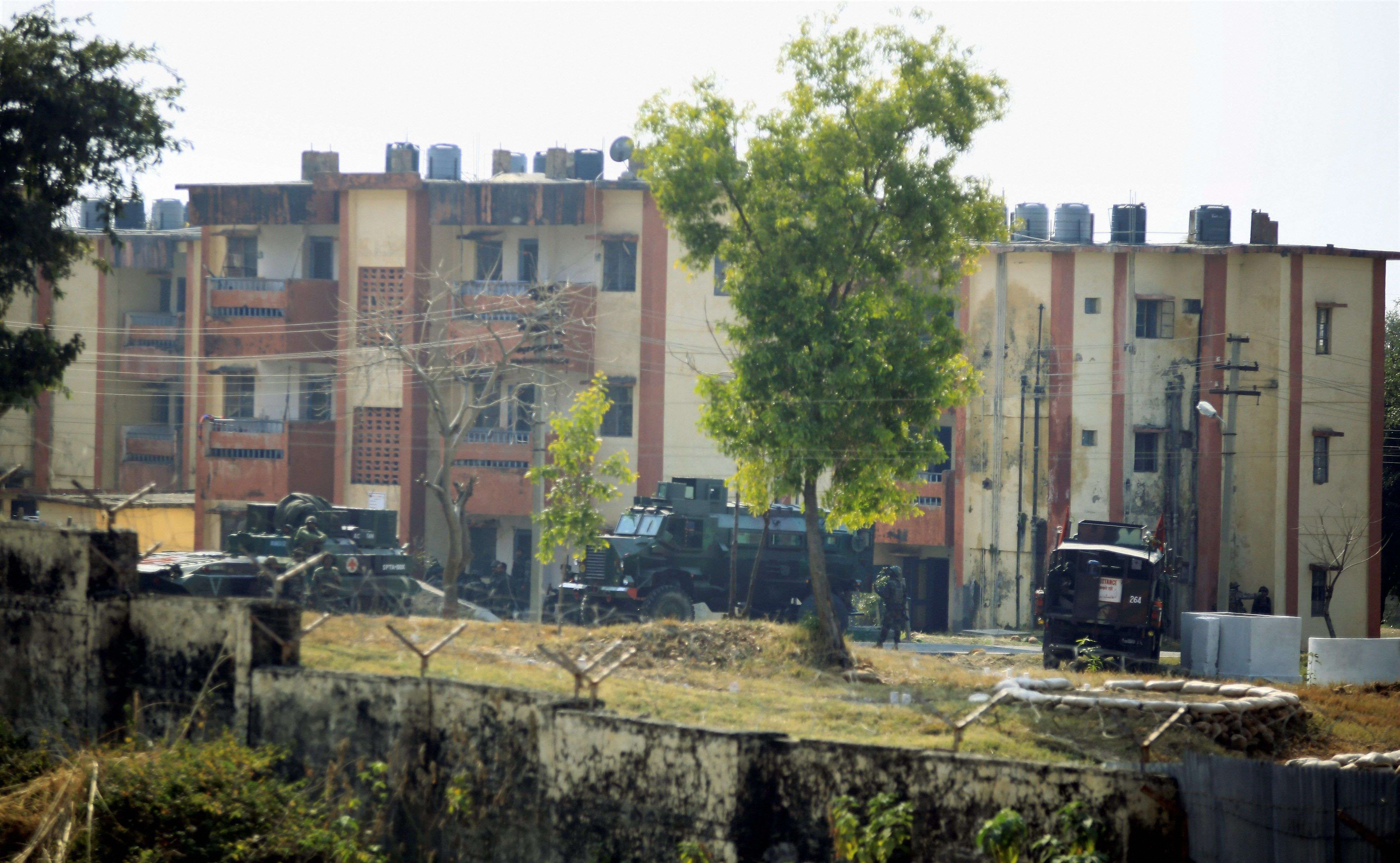 Security personnel take position around the family quarters of 36 Brigade Army camp in Sunjuwan area of Jammu on Saturday morning. PTI photo