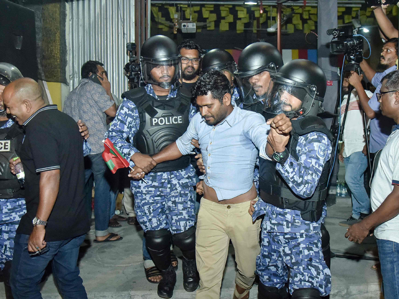 Maldivian police officers detaining an opposition protester (C) demanding the release of political prisoners during a protest in Male. (AFP)