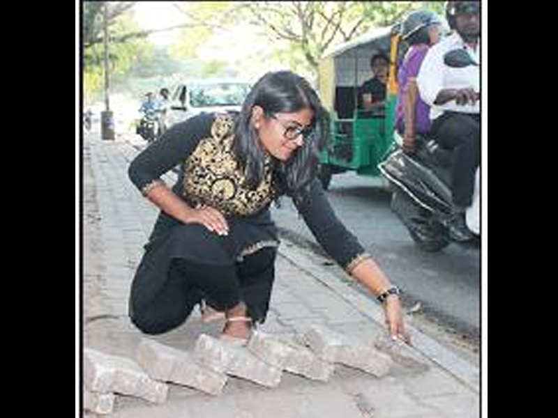  Manju Thomas lays stones on a pavement to prevent riders from using the space.