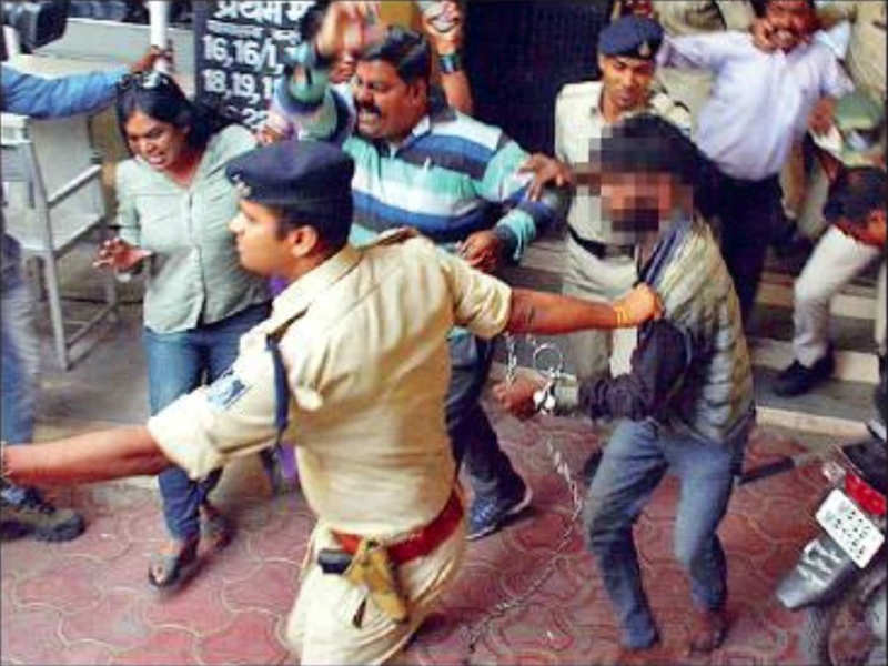 Police drag the accused as he was chased and beaten up by protesters at Indore district and sessions court on Saturday.
