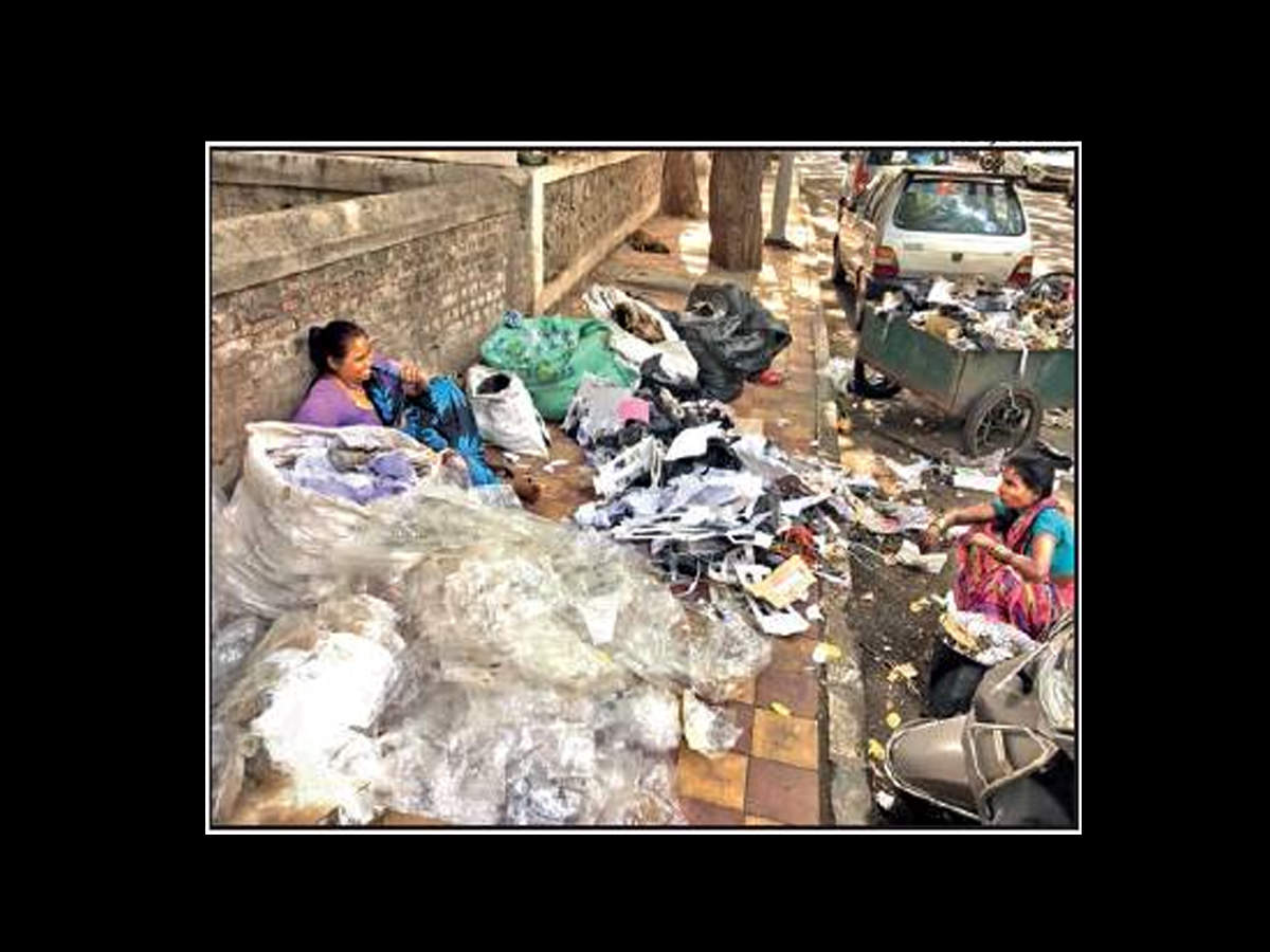 Waste pickers segregate plastic from garbage near Apte Road.