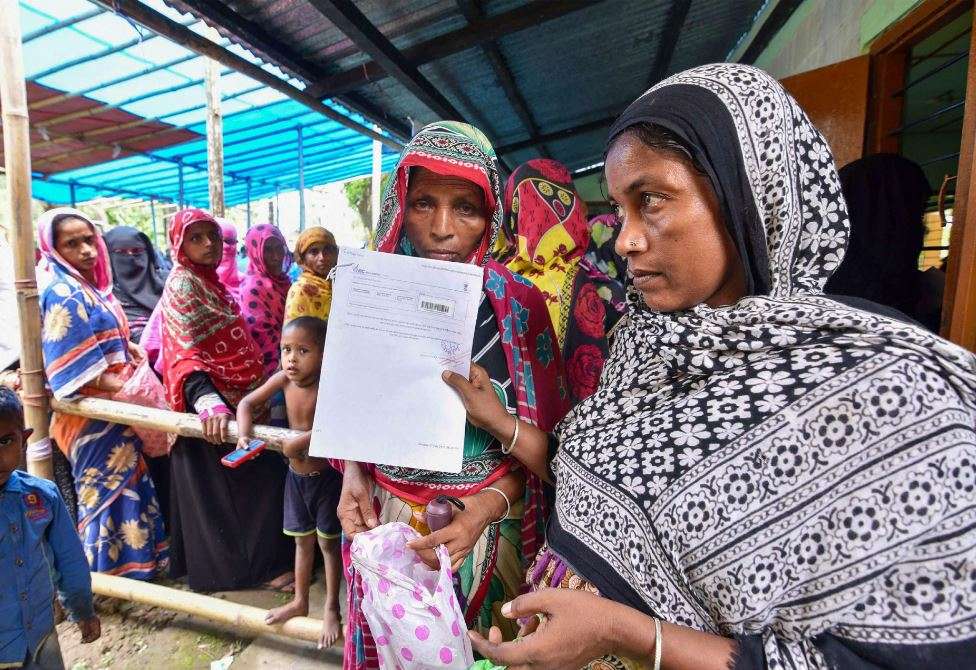People wait to check their names on the final draft of the state's National Register of Citizens at an NRC Seva Kendra in Nagaon on Monday. (PTI Photo)
