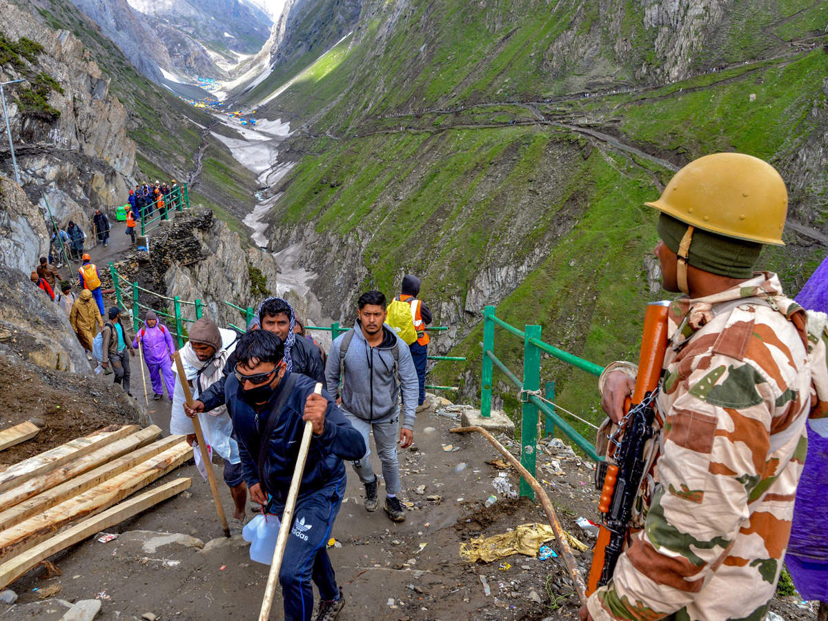 Security personnel look on as a batch of pilgrims proceed towards the holy cave shrine of Amarnath. (PTI file photo)
