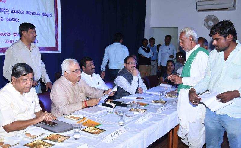 Revenue minister R V Deshpande interacts with a farmer during a progress review meeting at Alur Venkatrao Bhavan in Dharwad on Tuesday