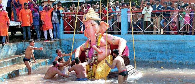 Goodbye:  An idol being immersed at a pond in Belagavi on Monday