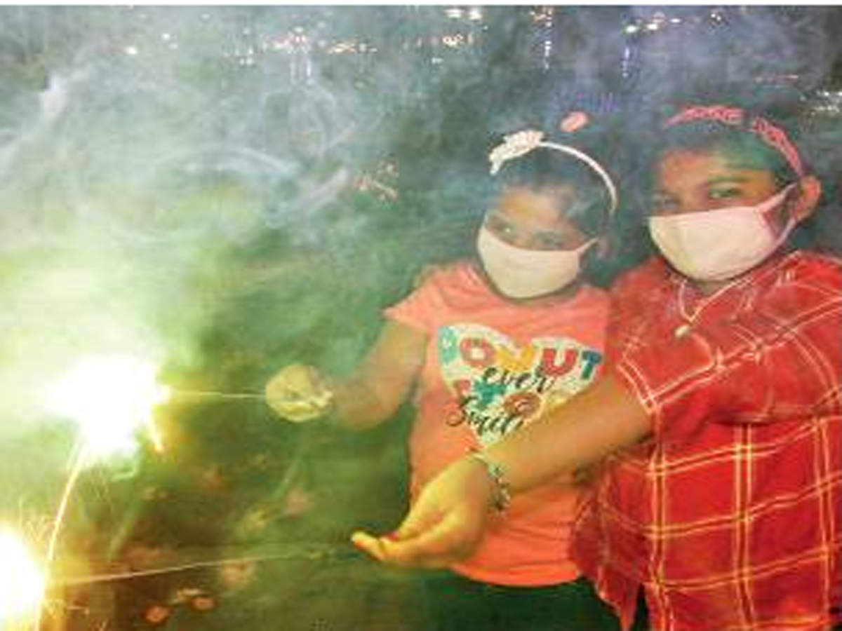 Children wear anti-pollution masks while setting off fireworks on Wednesday. 