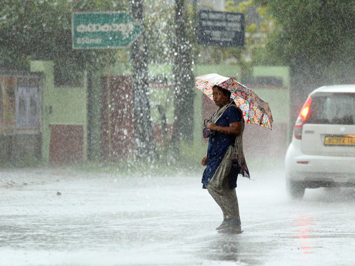 A woman struggles to wade through the road as heavy rain lashesd Kochi on Friday. (Photo: TOI)