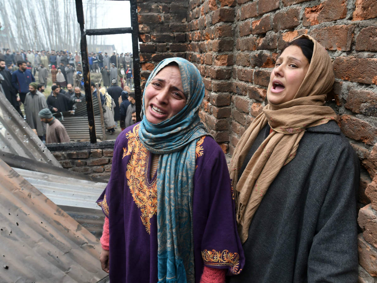 Women cry near a house where three terrorists were killed after an encounter in Mujgund area on the outskirts of Srinagar on December 9, 2018 (AFP)