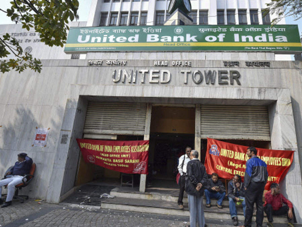 People stand outside a closed bank on the 2nd day of nationwide general strike called by the CITU against alleged anti-worker policies and unilateral labour reforms in Kolkata on Wednesday (Photo: AP)