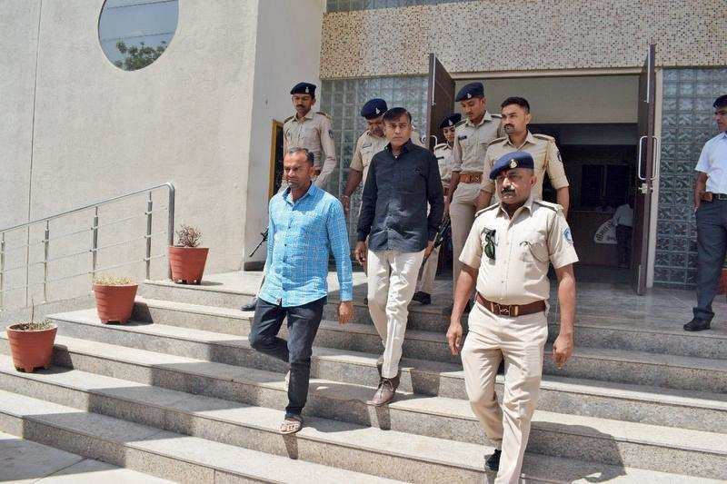 Ramji Marakana (in blue shirt) and Haresh Chothani (in black shirt) being taken to jail after the court sentenced them to life imprisonment