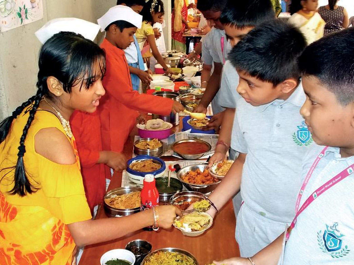 Students from Royaal World School serve food to their classmates