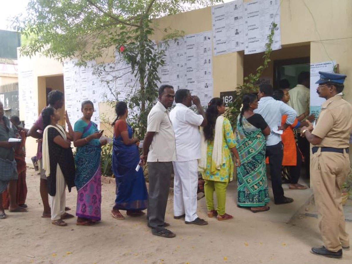 Voters waiting in a queue to cast their vote at a polling station in Perambur assembly constituency bypoll in Tamil Nadu.