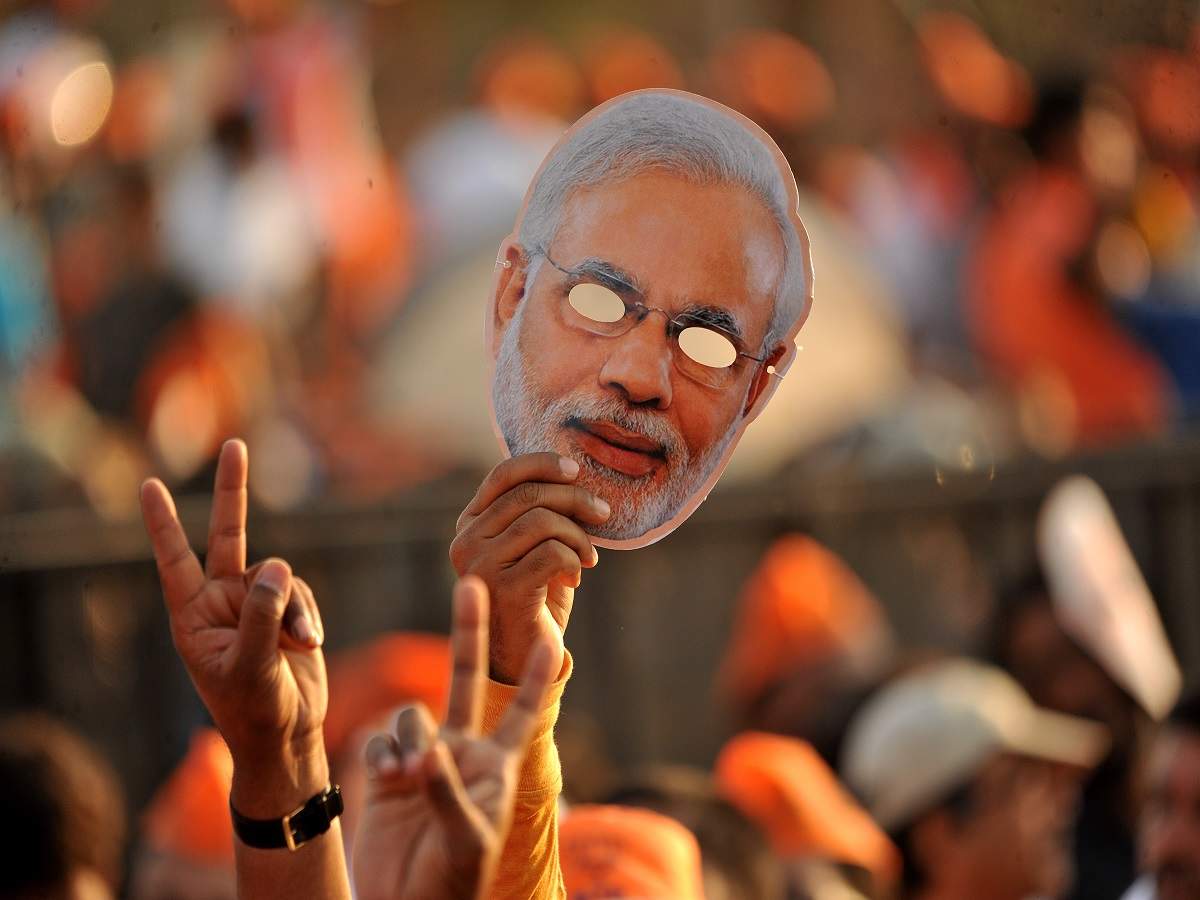 BJP supporters with cut outs and masks of PM Modi during a rally (File Photo)
