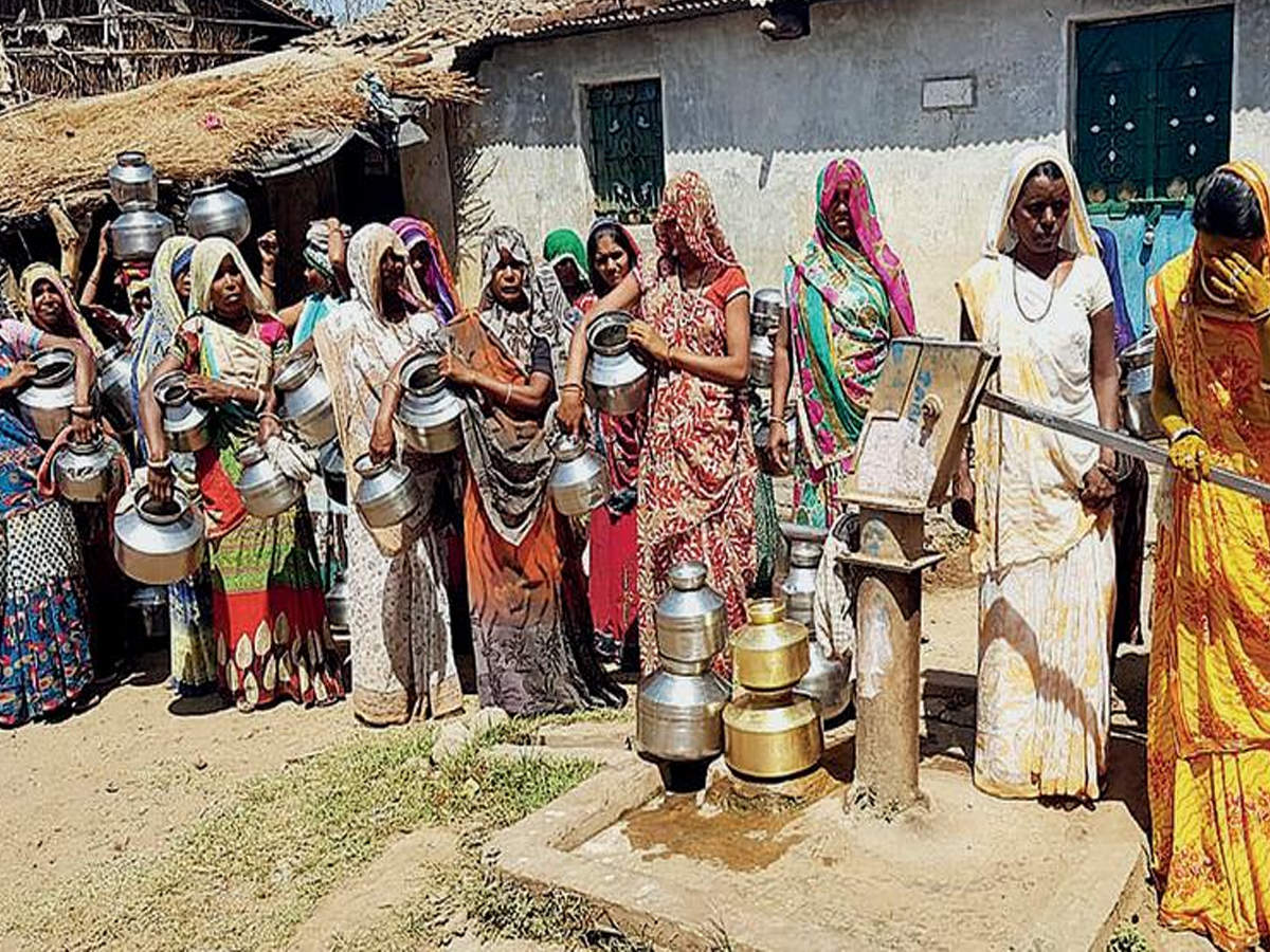 The bride (in yellow sari) along with other villagers getting water to serve the guests at her wedding in Jambughoda village