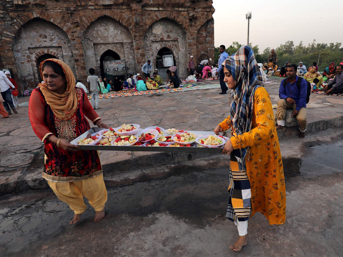 Muslims women carry plates of fruit for Iftar meals during Ramzan at the Feroz Shah Kotla mosque in New Delhi.