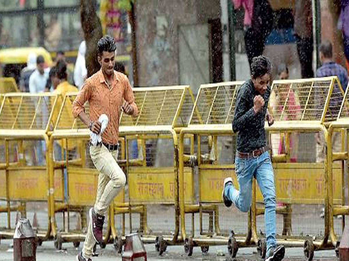 People run for cover from sudden rain at Narain Singh Circle in the city on Saturday
