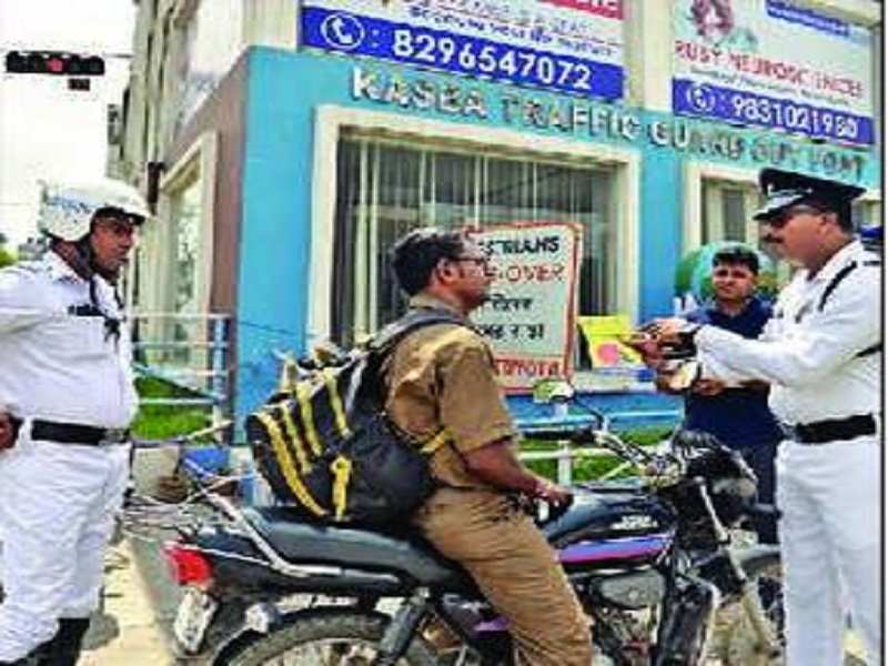 Traffic cops give out leaflets to helmetless bikers, including students, at Kasba on Monday morning