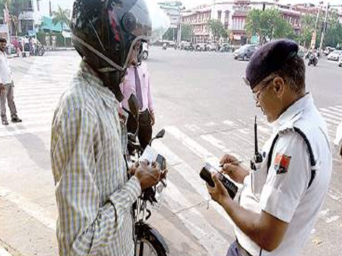 A cop issues a challan to a traffic violator in Jaipur on Wednesday