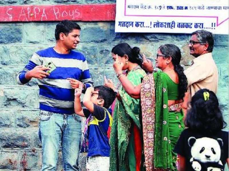 A family takes a selfie after casting their votes at the polling booth at Bunter School in Hadapsar on Monday