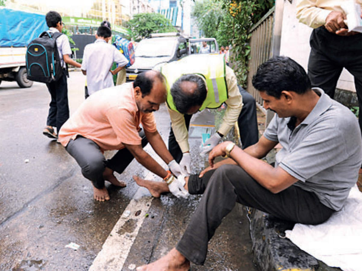 Prabhadevi shopowner Ravindra Kadam (in reflector jacket) demonstrates how to attend to a road crash victim 