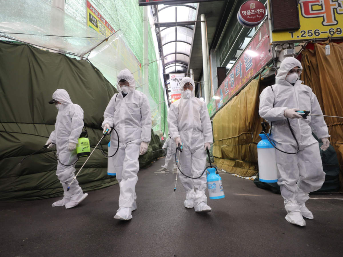 Market workers wearing protective gear spray disinfectant at a market in the southeastern city of Daegu in South Korea, on February 23, 2020 as a preventive measure after the COVID-19 coronavirus outbreak (AFP)