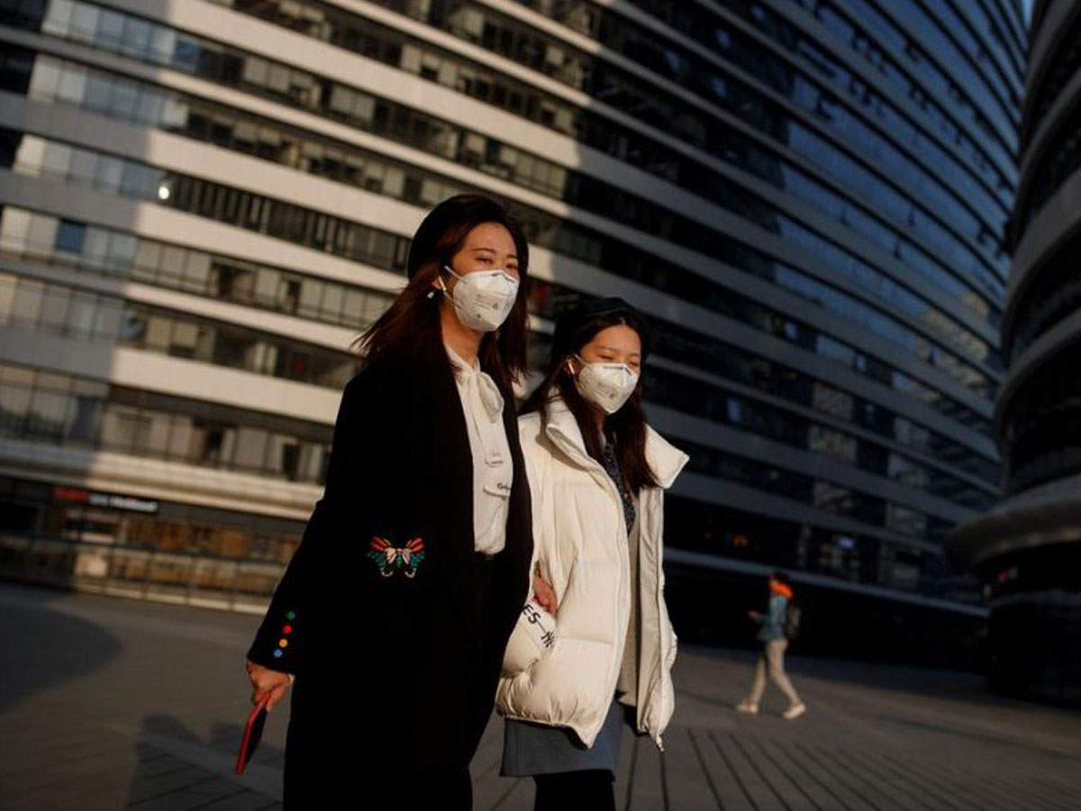 Women wears face masks outside an office complex in Beijing as the country is hit by an outbreak of the novel coronavirus, in China, on March 11, 2020. (Reuters photo)
