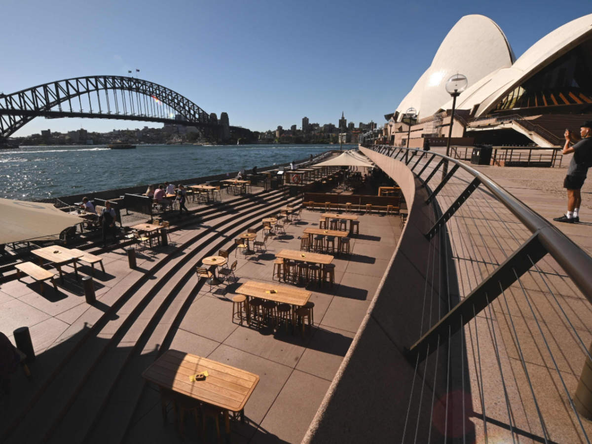 A lone tourist takes a photo in Circular Quay in Sydney on March 20, 2020 (AFP)