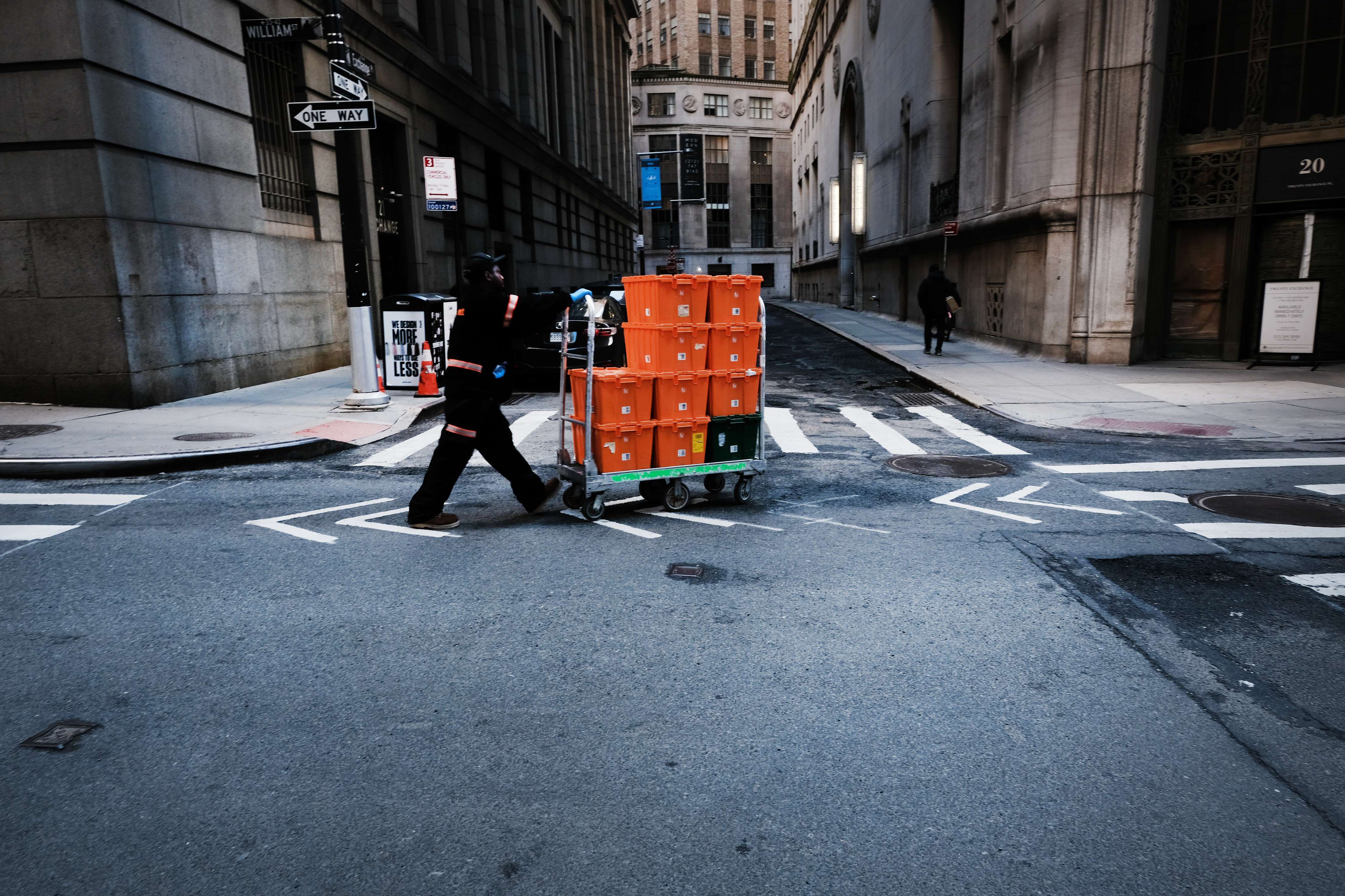 A man makes deliveries near Wall Street as people stay away from the area due to the coronavirus on March 24, 2020 in New York City (AFP)