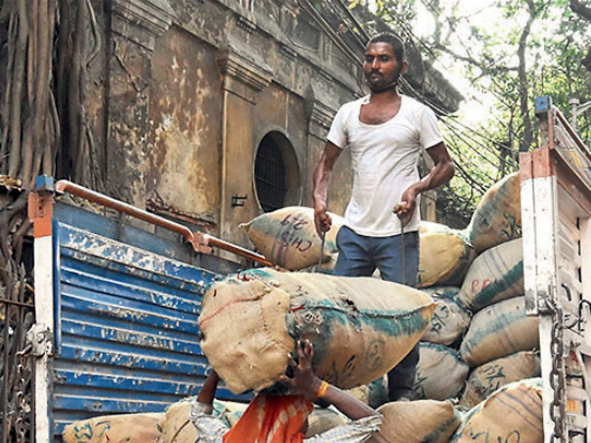 Workers unload gunny bags of vegetables in central Kolkata