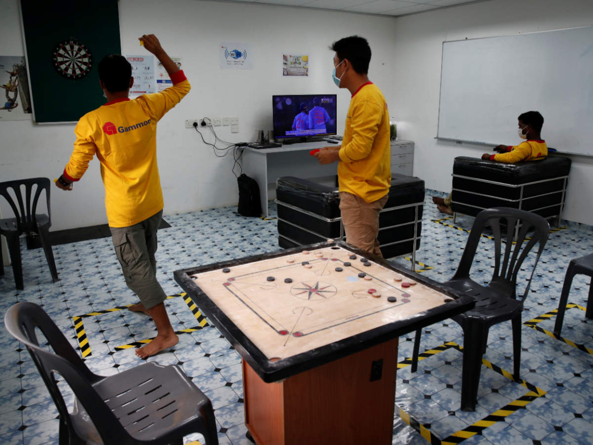 Migrant workers throw darts in a recreation room of their temporary living quarters for essential migrant workers amid the coronavirus disease (COVID-19) outbreak in Singapore (Reuters)