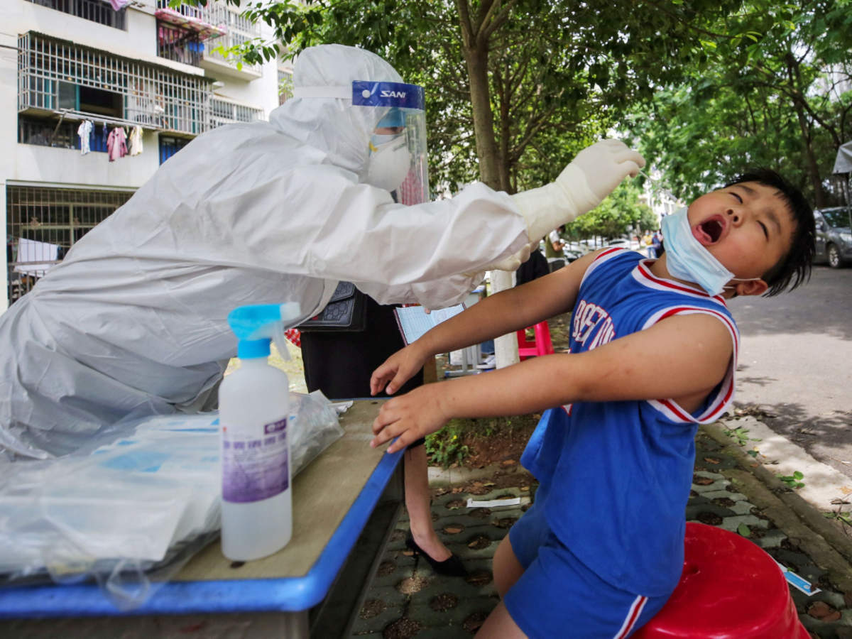 A medical worker taking a swab sample from a child to be tested for the Covid-19 coronavirus, in a street in Wuhan, in China (AFP)