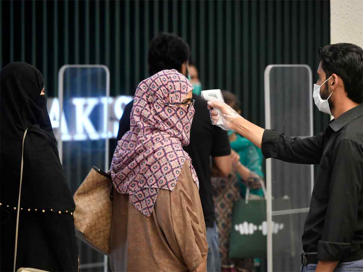 A man checks the body temperature of a customer before shopping at a mall after the government eased a nationwide lockdown imposed as a preventive measure against the COVID-19 coronavirus, in Islamabad. (AFP Photo)