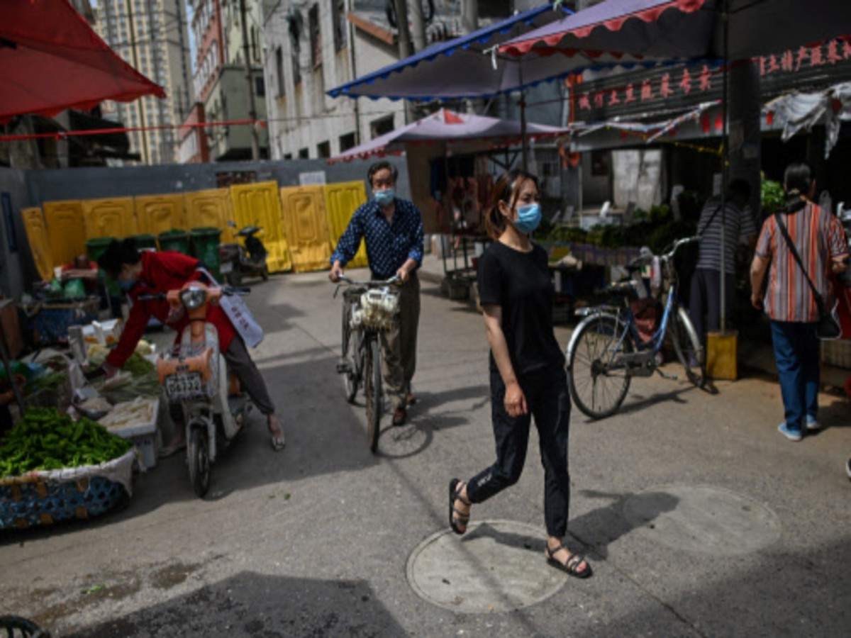 People wearing face masks walk in a market in Wuhan: AFP