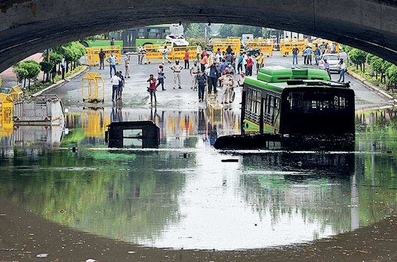 A DTC bus almost submerged at waterlogged Minto Bridge underpass after rains in New Delhi, Sunday. A tempo driver died due to drowning of his vehicle at the underpass. (Photo - Yogesh Kumar)