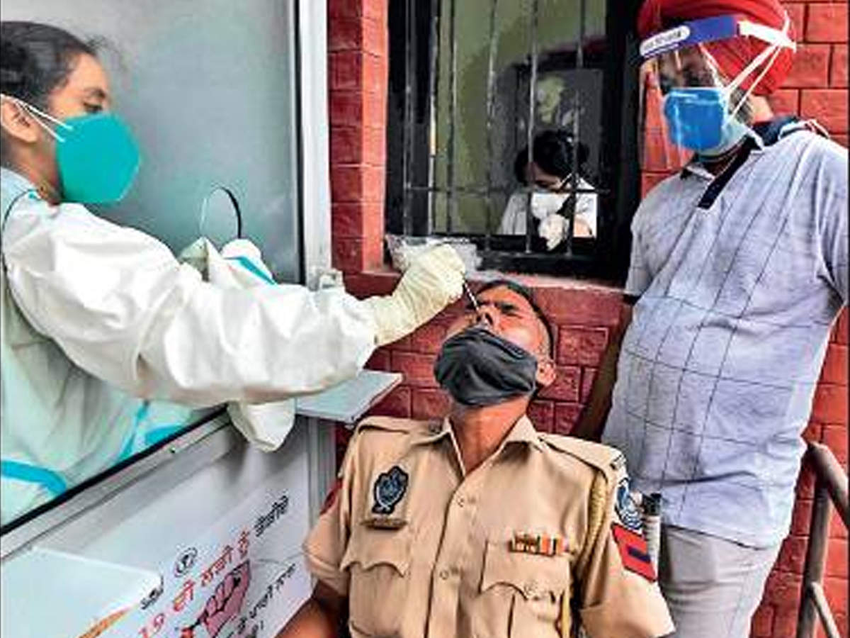 A health official collects nasal swab of a policeman in Amritsar