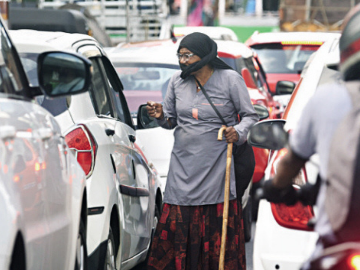 An elderly women seeking alms from motorist at Palavrivattom in Kochi on Thursday