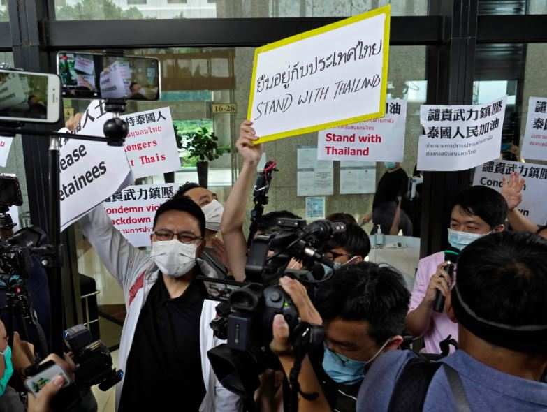Hong Kong: protesters raise placards during a protest outside an office building in Central, where the Royal Thai Consulate-General in Hong Kong is located 