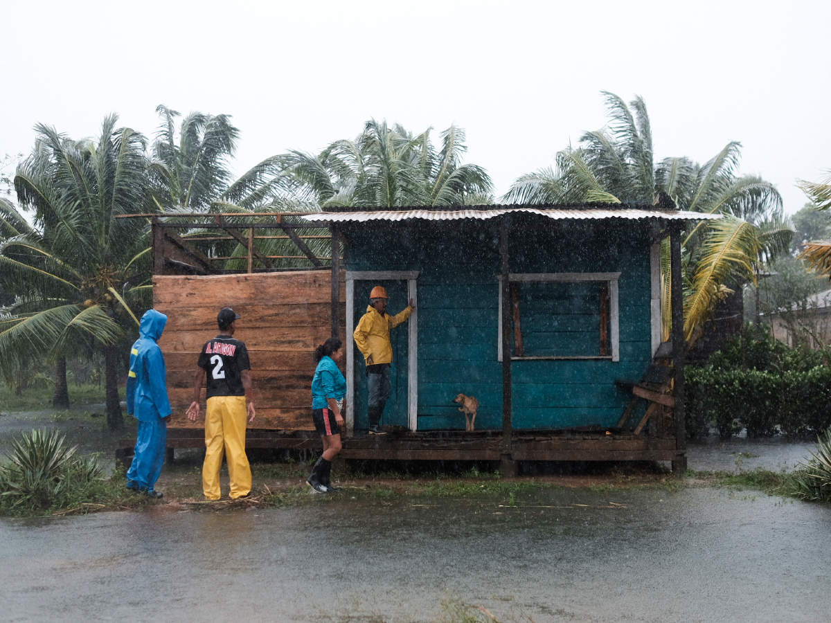 Residents stand outside a home surrounded by floodwaters brought on by Hurricane Eta in Wawa, Nicaragua, Tuesday, Nov. 3, 2020 (AP)