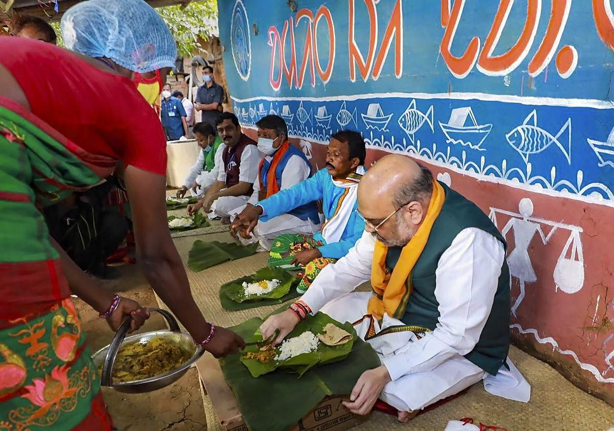 Home minister Amit Shah has lunch with a Santhal family in a Bankura village in West Bengal on Thursday. The TMC government seized upon the moment to appoint Gita Mahali, the tribal woman at whose residence Shah had lunch in 2017, as a home guard (PTI photo)