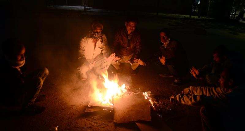 Some people warming themselves around a bonfire in Dehradun