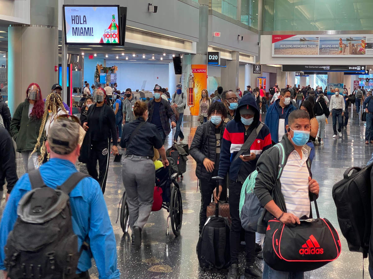 Travellers wear facemasks at Miami International Airport on December 24, 2020, amid the coronavirus pandemic (AFP)