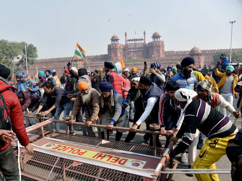 Protesting farmers break police barricades to enter Red Fort during the tractor rally. (ANI Photo)