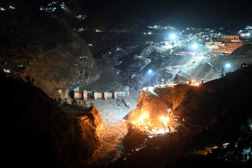 Floodlights are lit around the Tapovan tunnel area where rescuers are searching for trapped workers in Chamoli district (AFP)