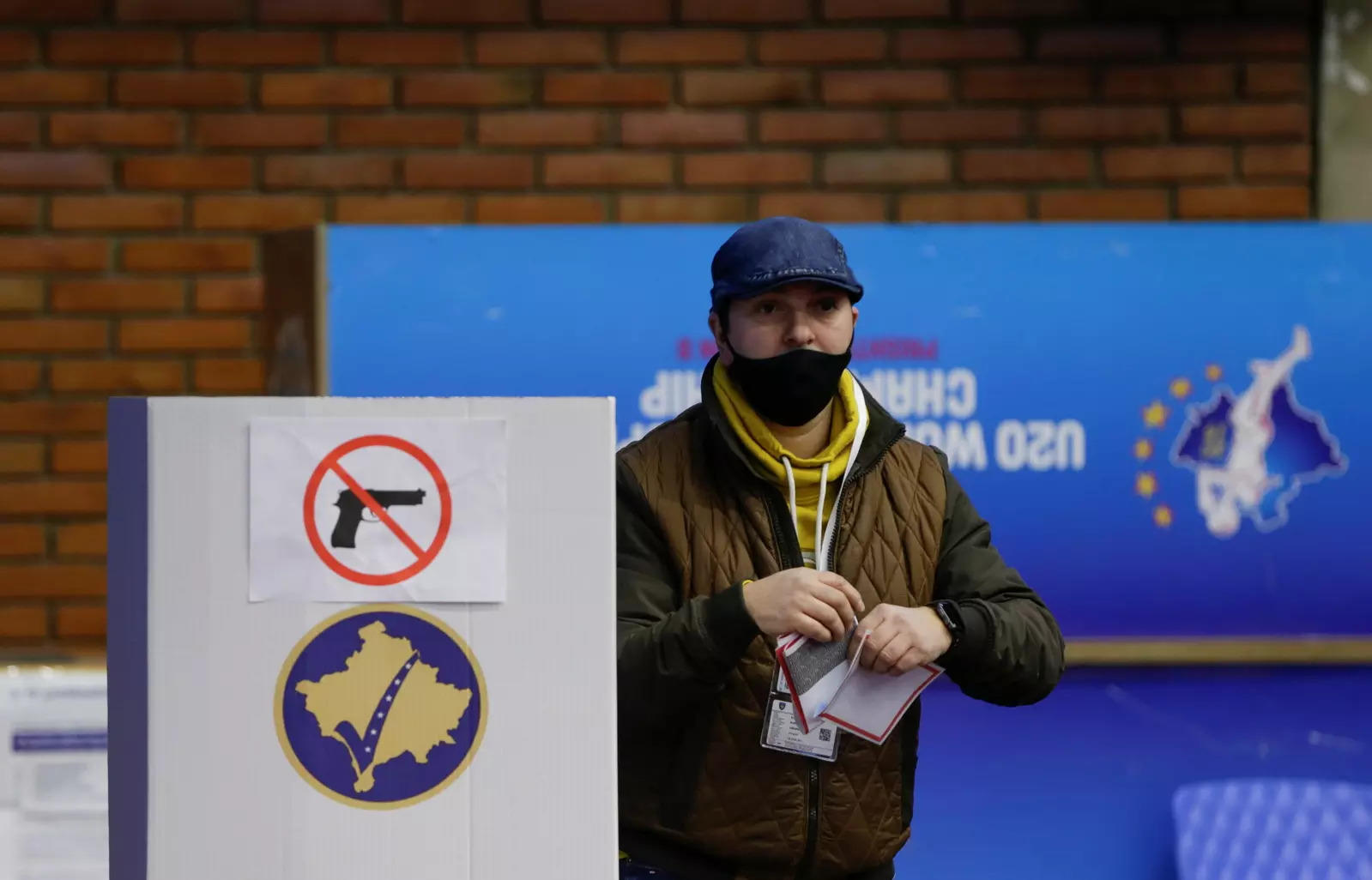 A man is seen next to a ballot box during parliamentary elections in Pristina, Kosovo 