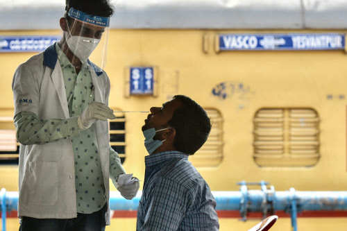 A health worker takes a nasal swab of a passenger for a coronavirus test (Photo credit: AFP)