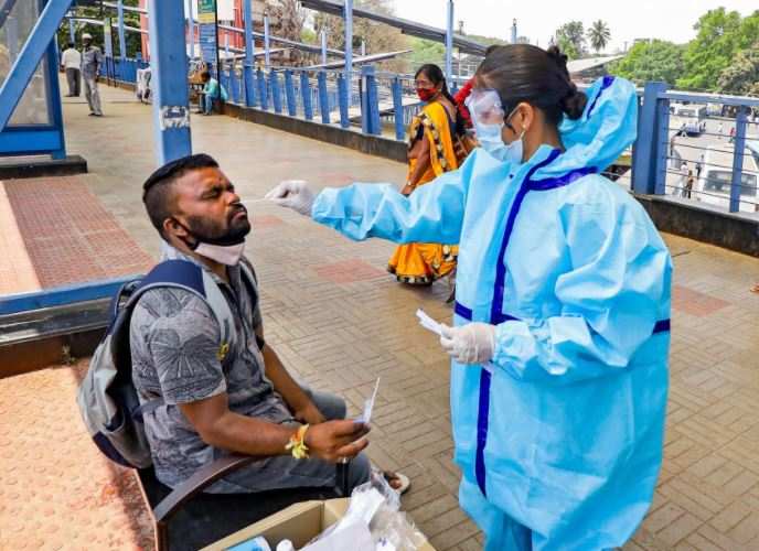 A health worker takes a swab sample from a man for COVID-19 test, at Kempegowda bus stand in Bengaluru (PTI)